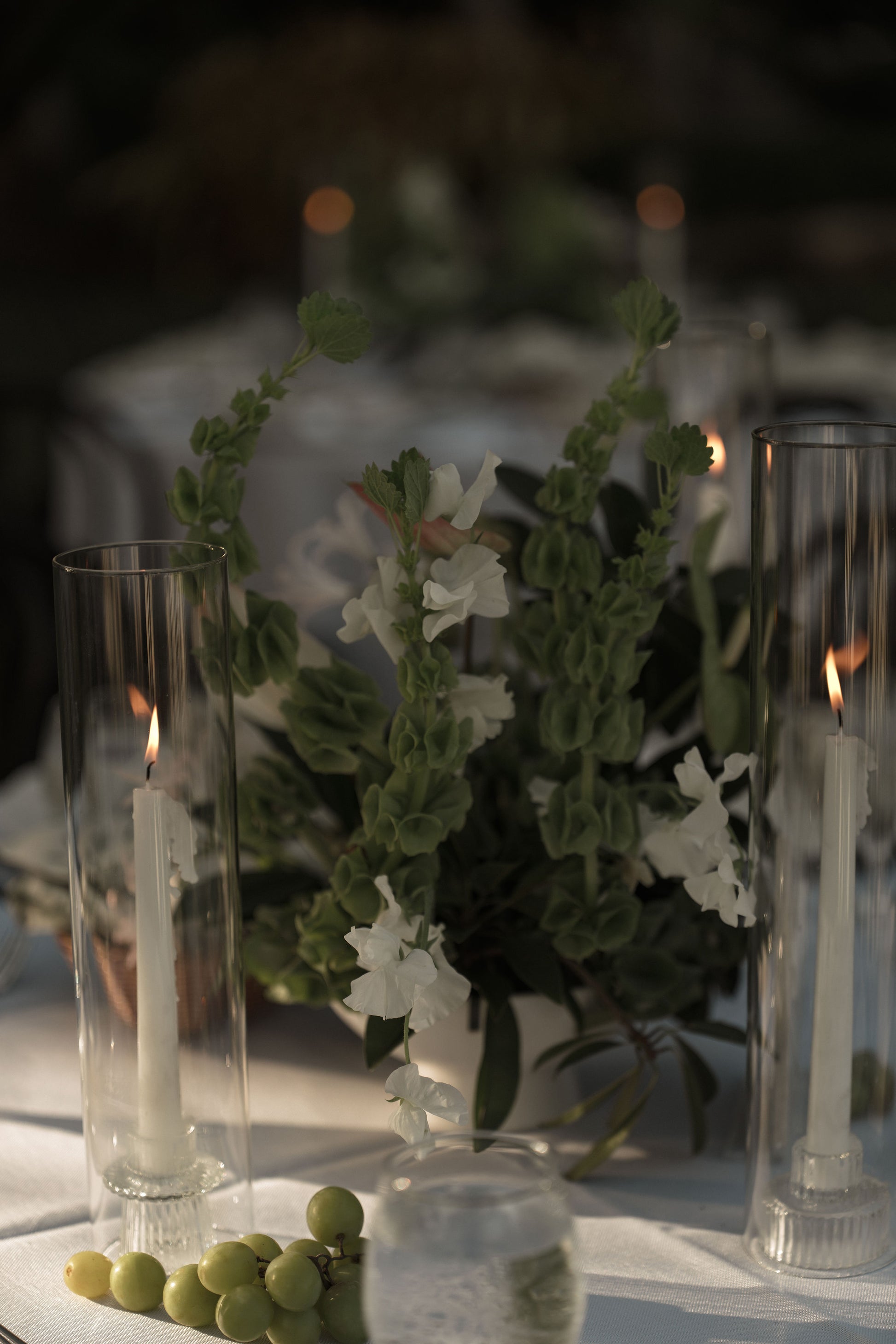 Decorative table setting with candles and flowers on a dark background