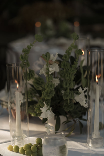 Decorative table setting with candles and flowers on a dark background