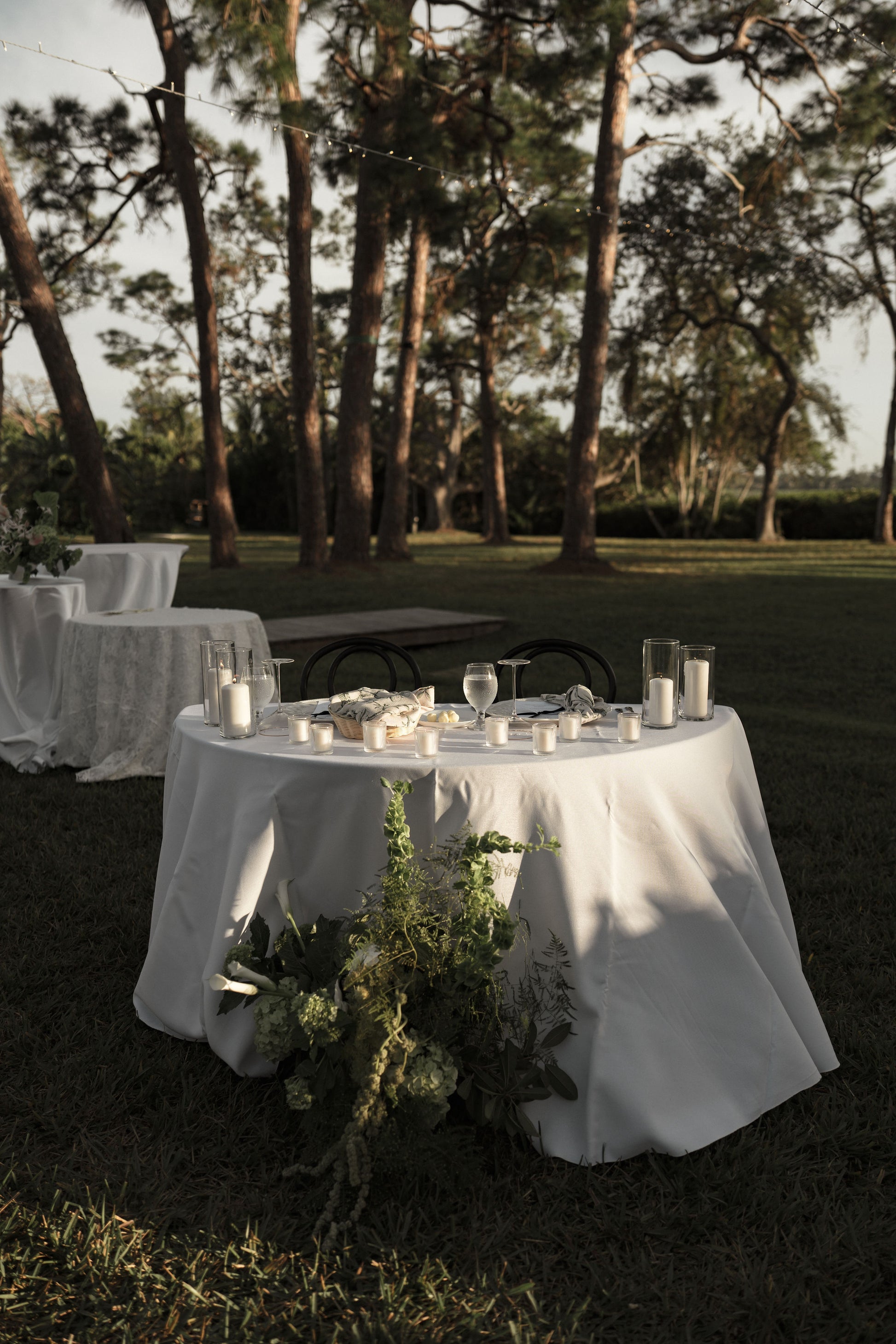 Outdoor setting with tables and chairs under trees