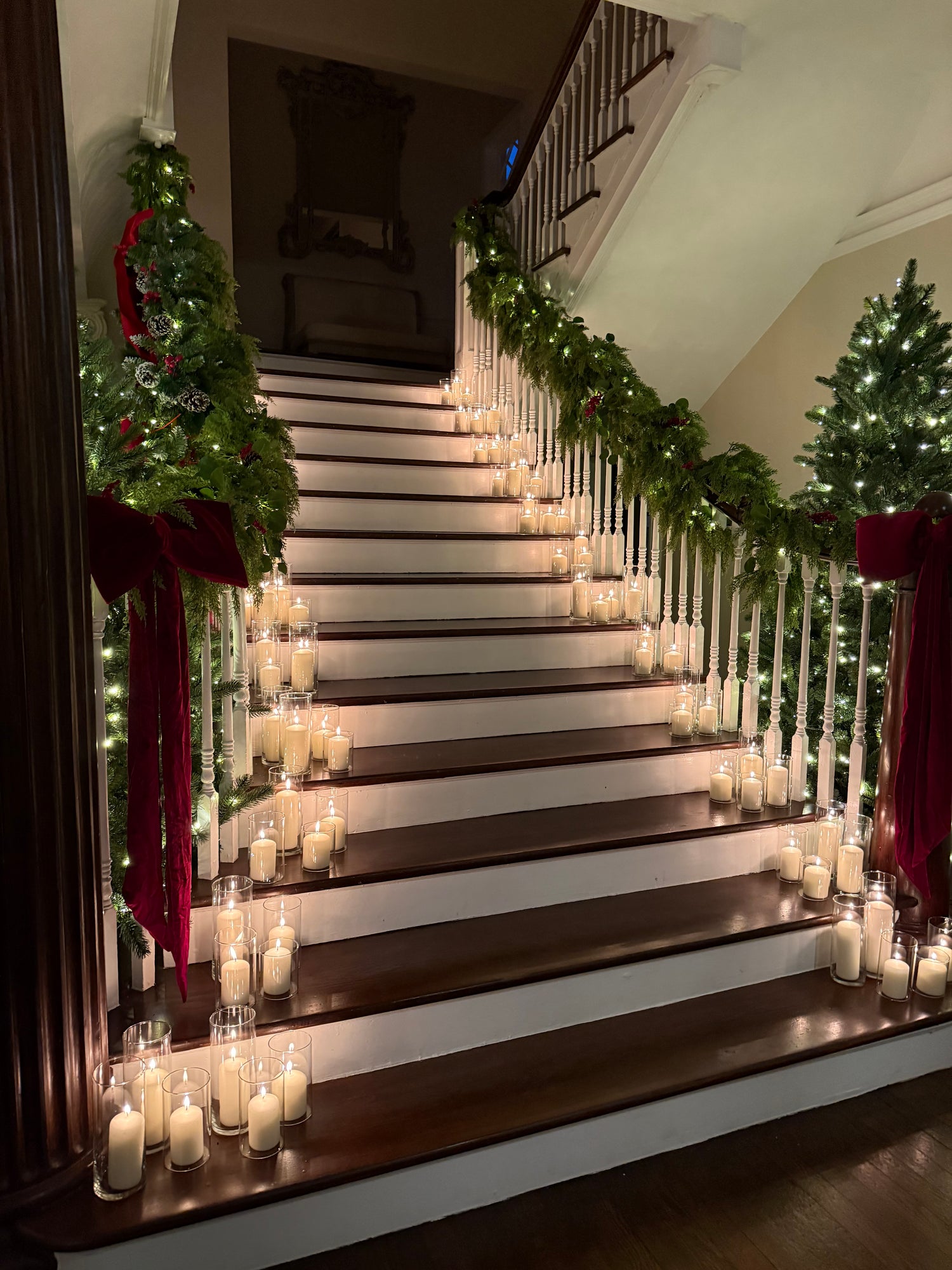 Decorative staircase with lights and greenery, likely during a festive season.