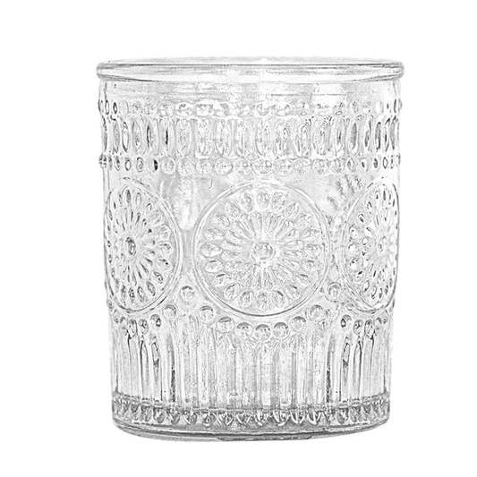 Clear glass candle holder with decorative patterns on a white background
