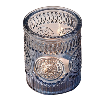 Decorative glass candle holder with intricate patterns on a white background