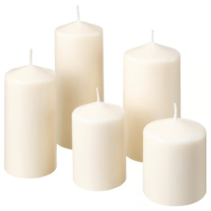 Set of five white candles of different sizes on a white background
