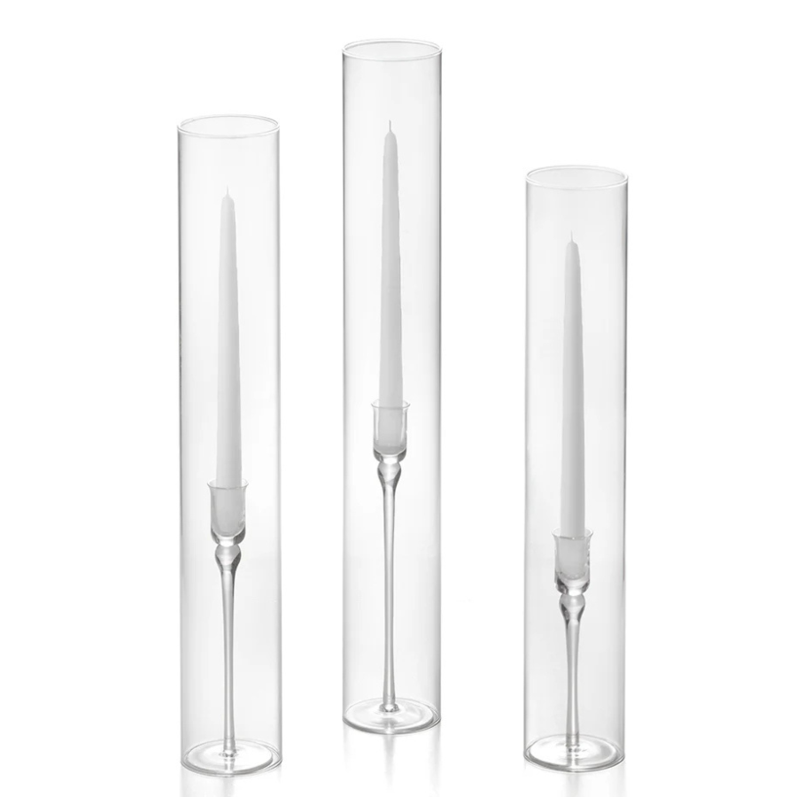 Three clear cylindrical candle holders with white candles on a white background