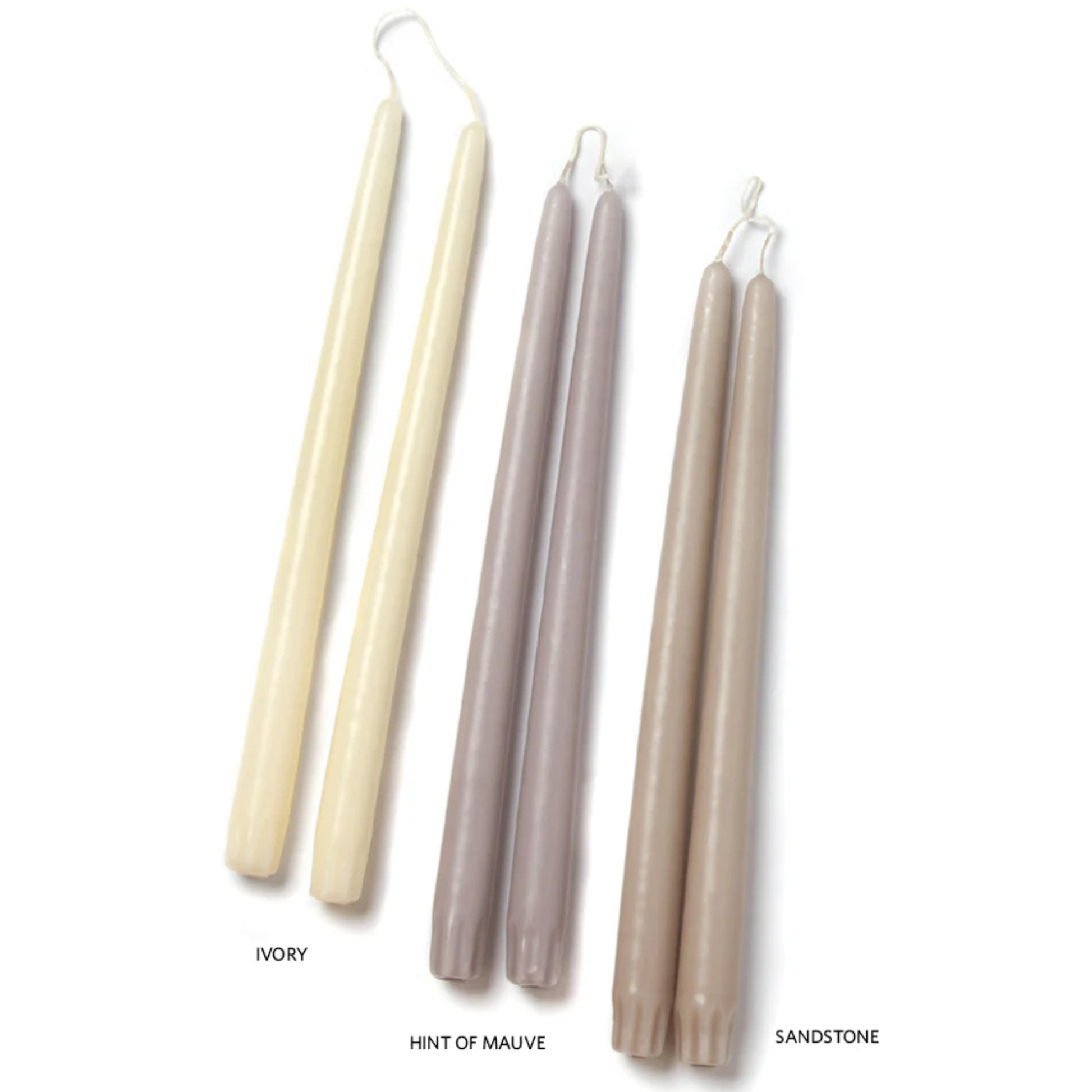 Set of four candles in ivory, hint of mauve, and sandstone on a white background