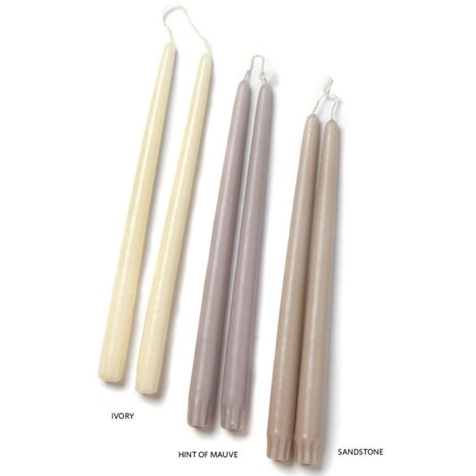 Set of four candles in ivory, hint of mauve, and sandstone on a white background