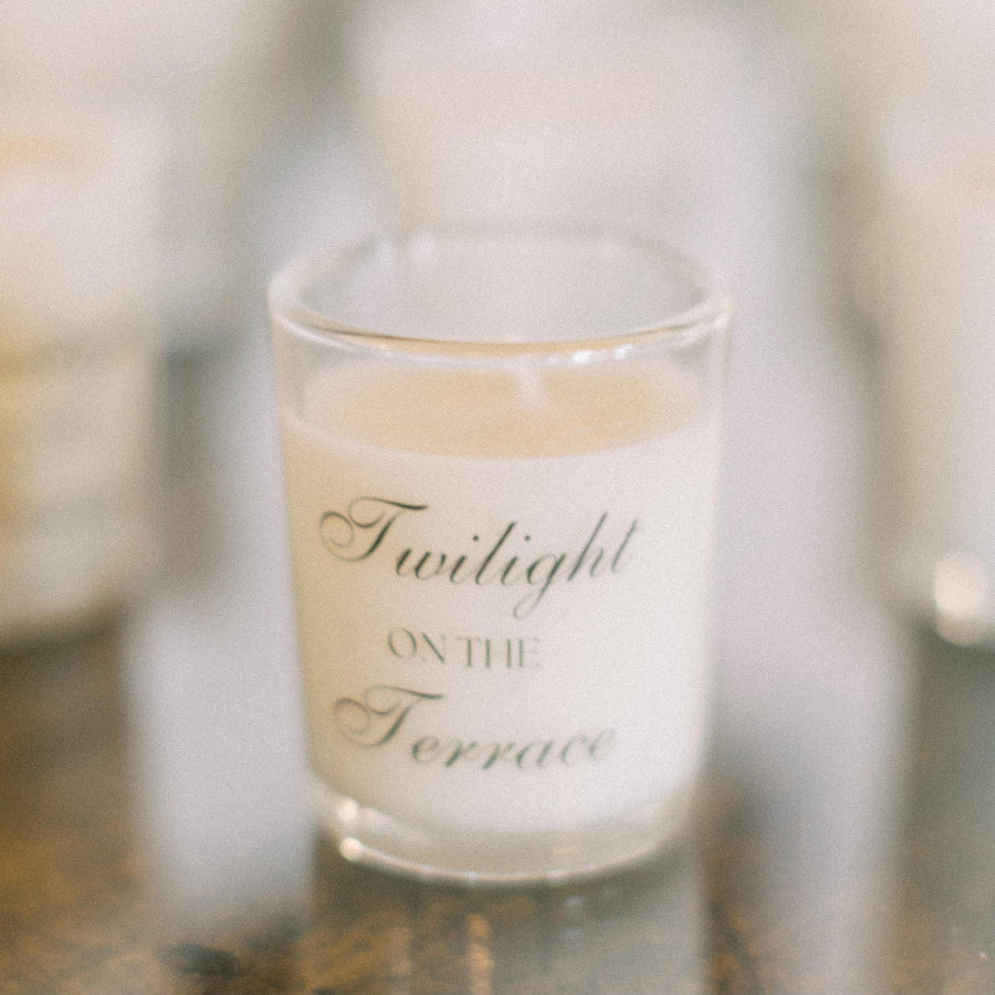 Glass candle with 'Twilight on the Terrace' text on a blurred background